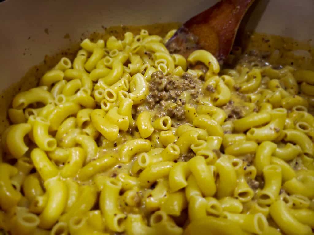 Macaroni mixed into cheese sauce