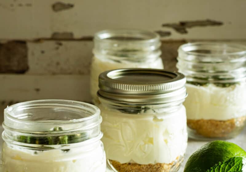 jars of no bake chhesecake with a lime and fresh mint