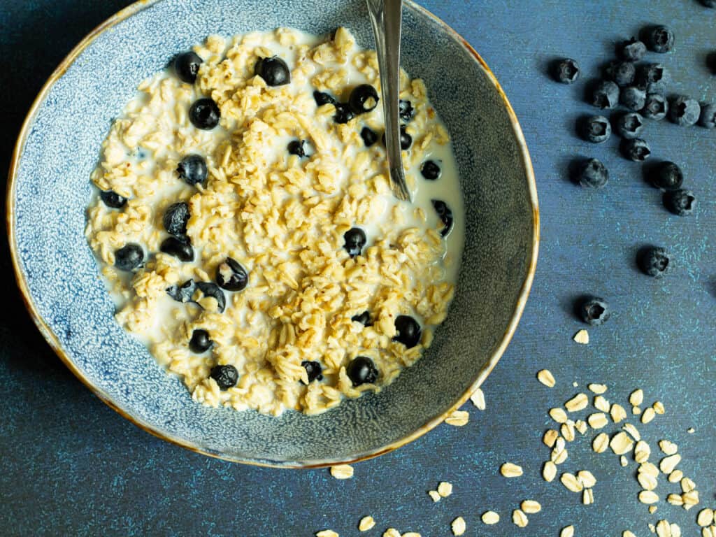 closeup photo of blueberry overnight oats in a blue bowl