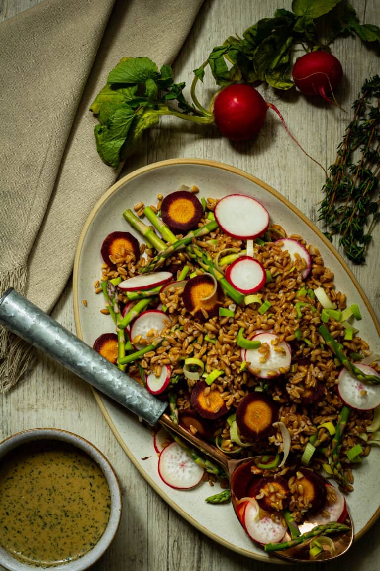 farro salad with a dish of vinaigrette and spoon