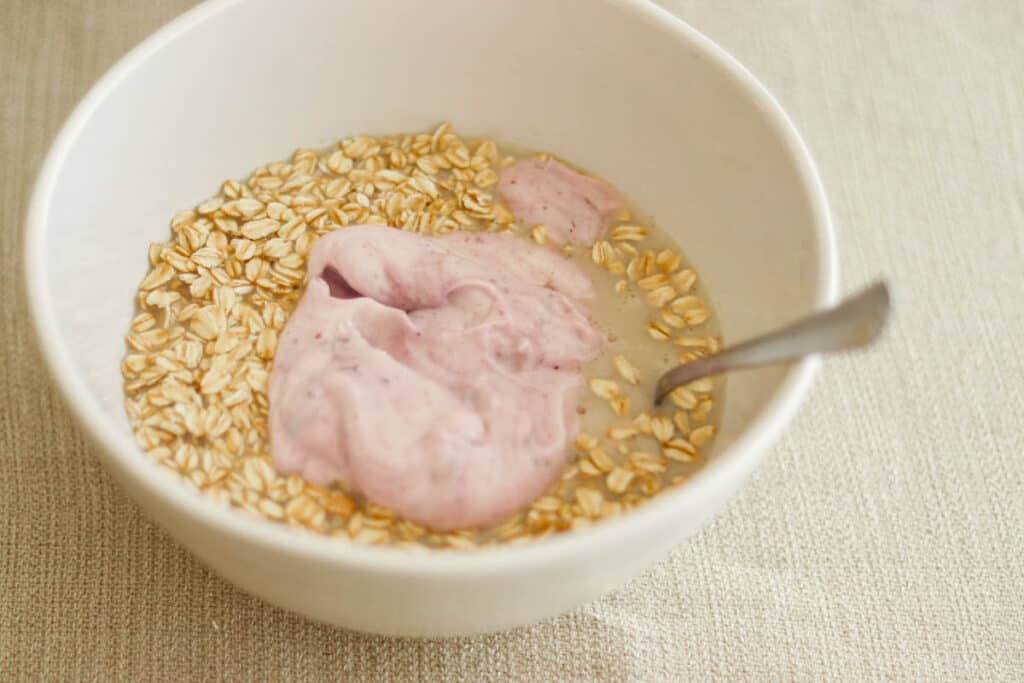 bowl of blueberry overnight oats ingredients in a bowl with a spoon