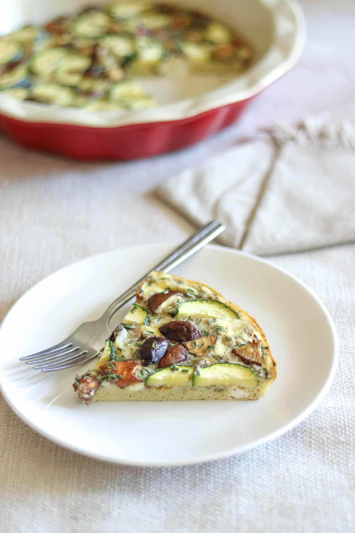 frittata slice on a plate with a pie dish