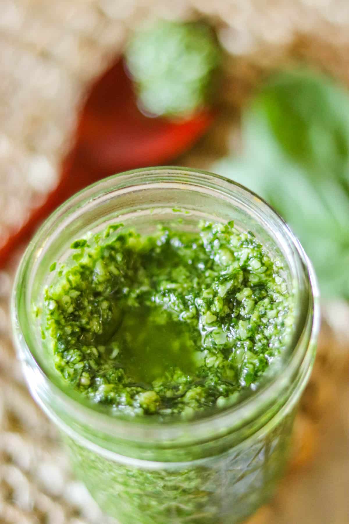 closeup picture of pesto in a glass jar.