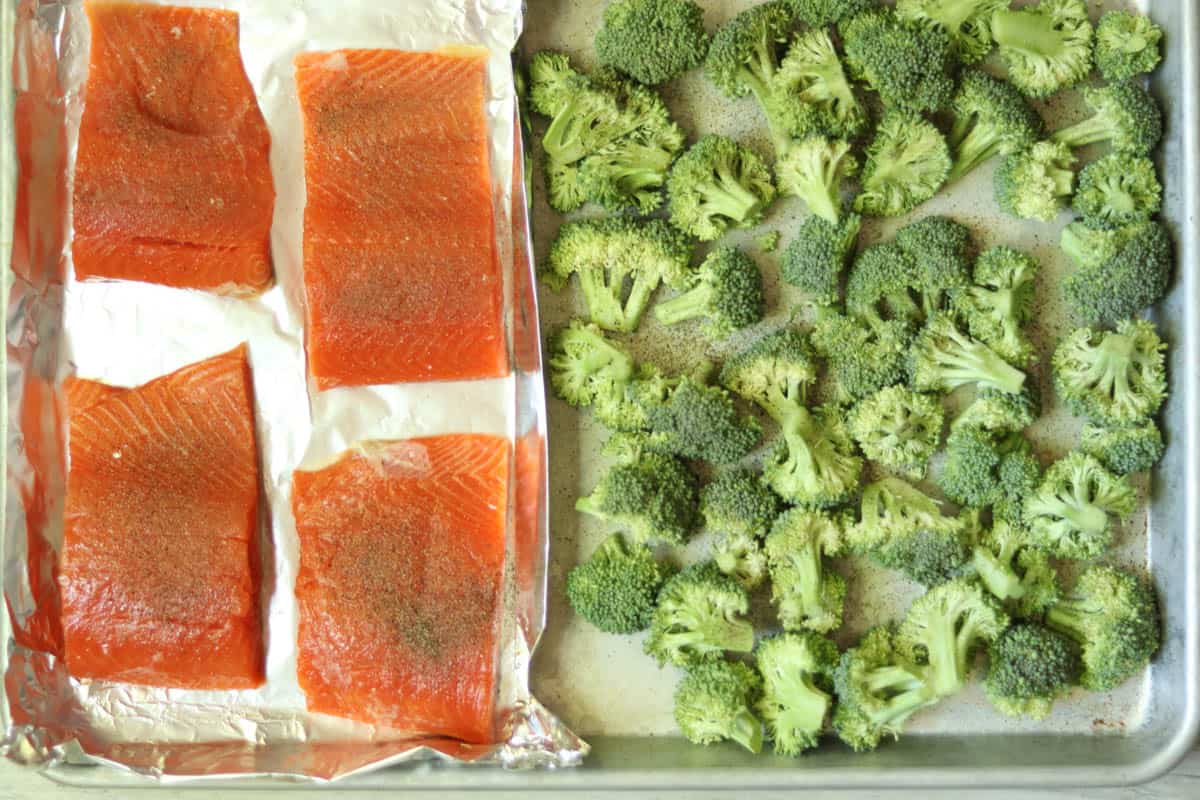salmon and brocolli on a foil lined sheet pan ready for baking.