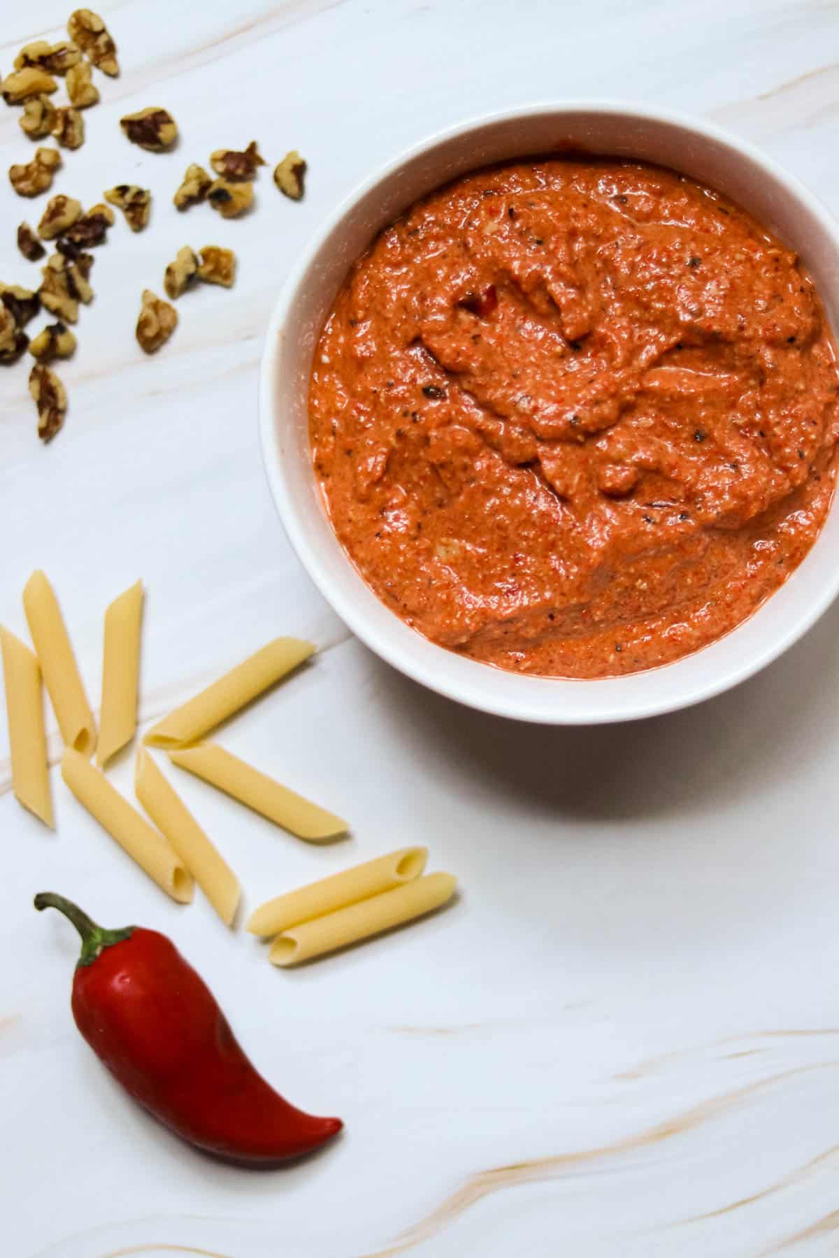 bowl of red pepper pesto on a white background.