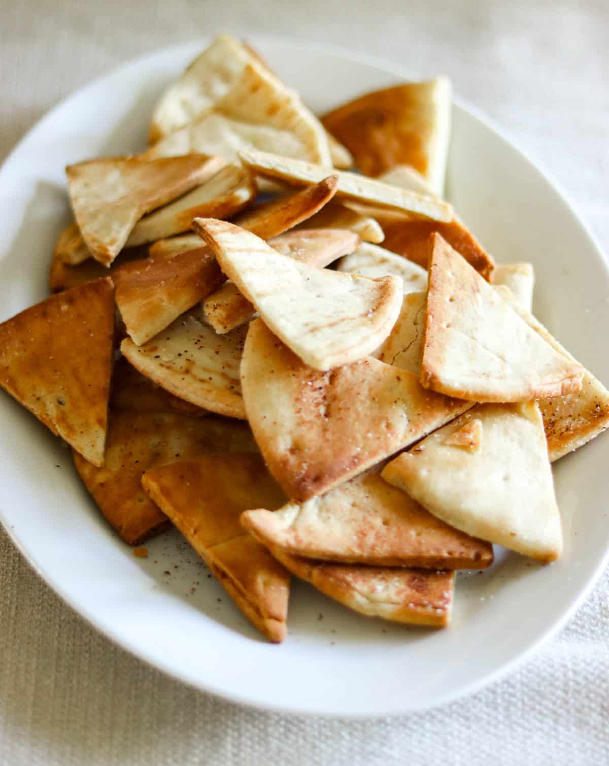 air fried pita chips on a white plate.