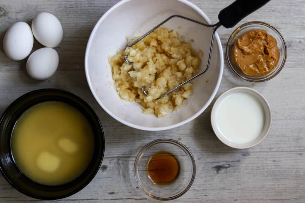 Photo of wet ingredients with a bowl of mashed bananas.