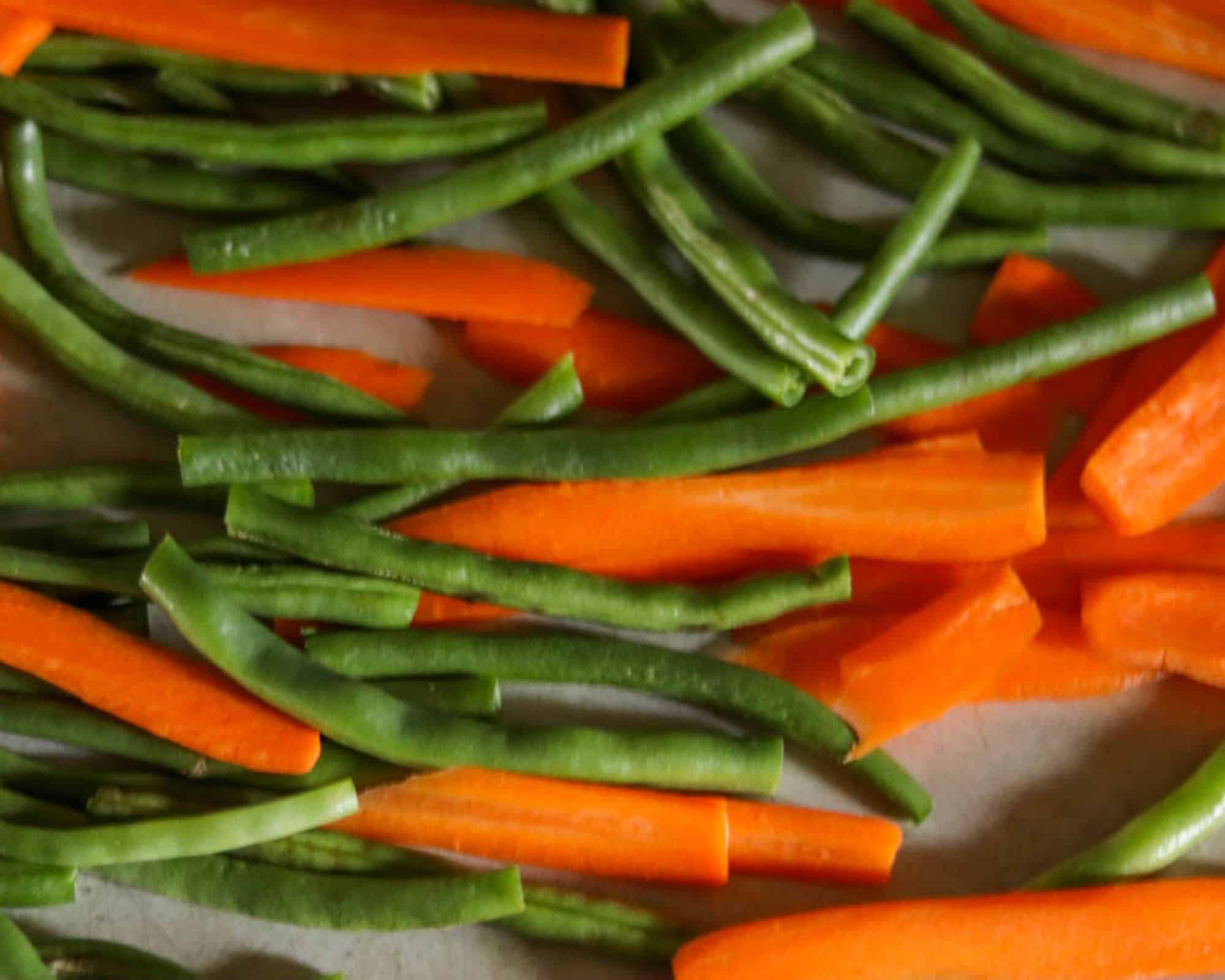 green beans and carrots on a sheet pan ready to roast.