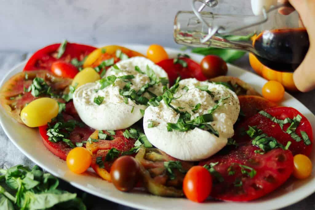 plate of caprese salad and a bottle of balsamic vinegar.