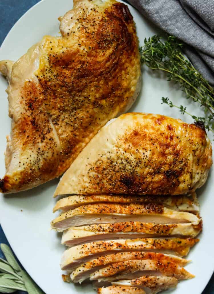 Two buttermilk brined turkey breasts on a white plate.