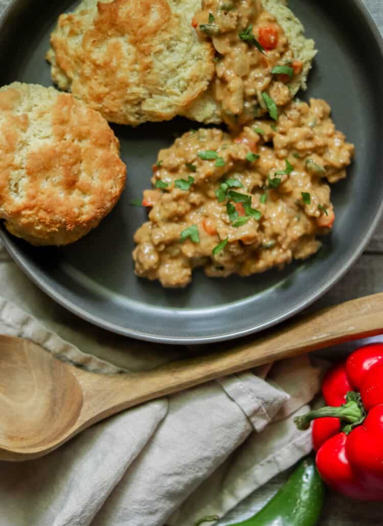 Chorizo biscuits and gravy on a gray plate.