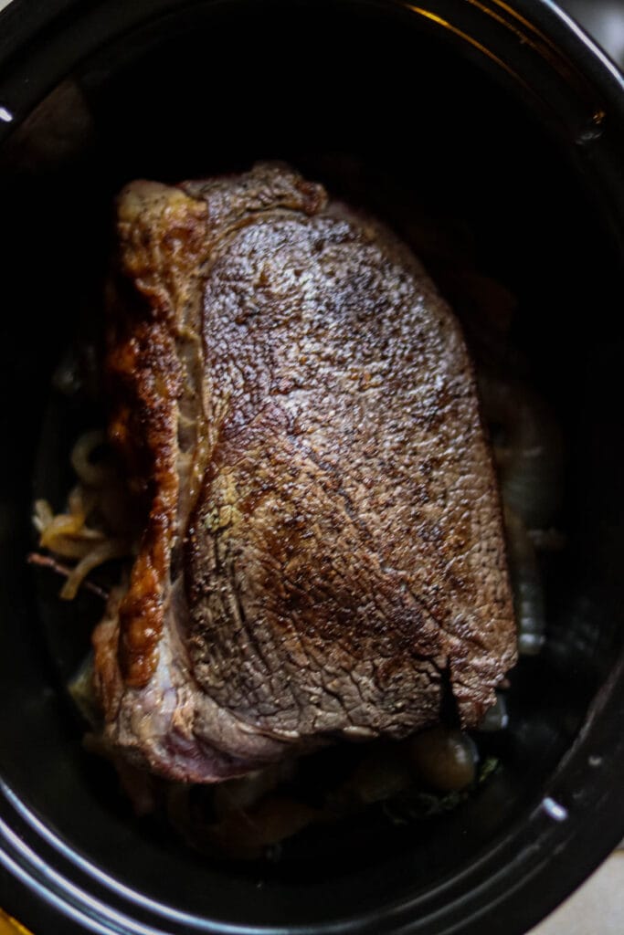 Browned roast inside the slow cooker.