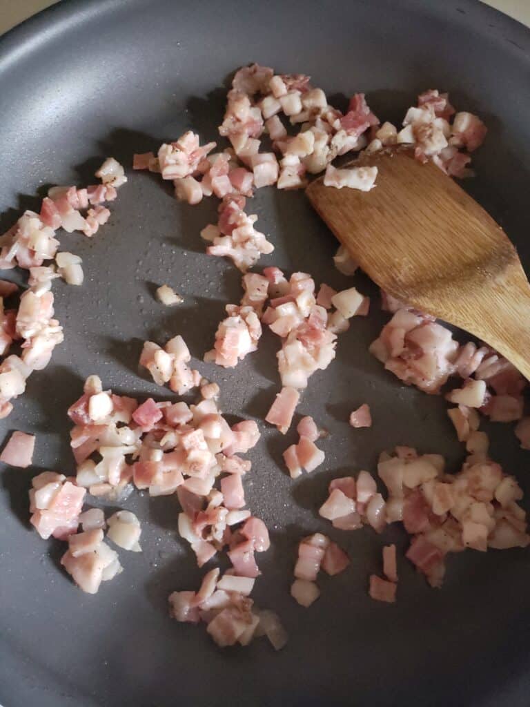 Pancetta browning in a skillet.