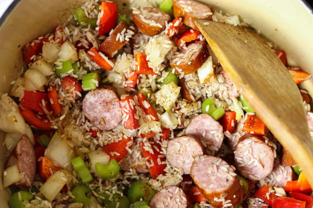 Cooking the rice, sausage, and vegetables.