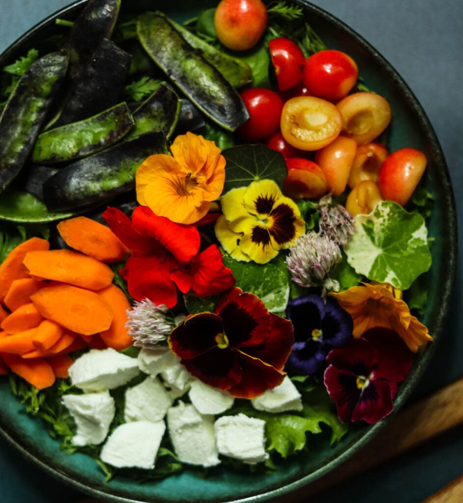 Large bowl of salad with edible flowers.