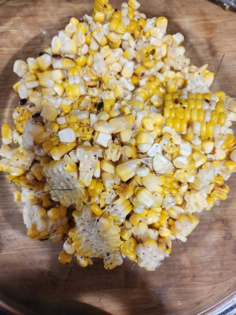 Cut grilled corn kernels in a bowl.