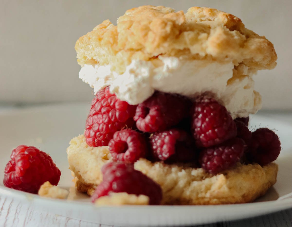 Closeup of shortcake biscuits and raspberries.