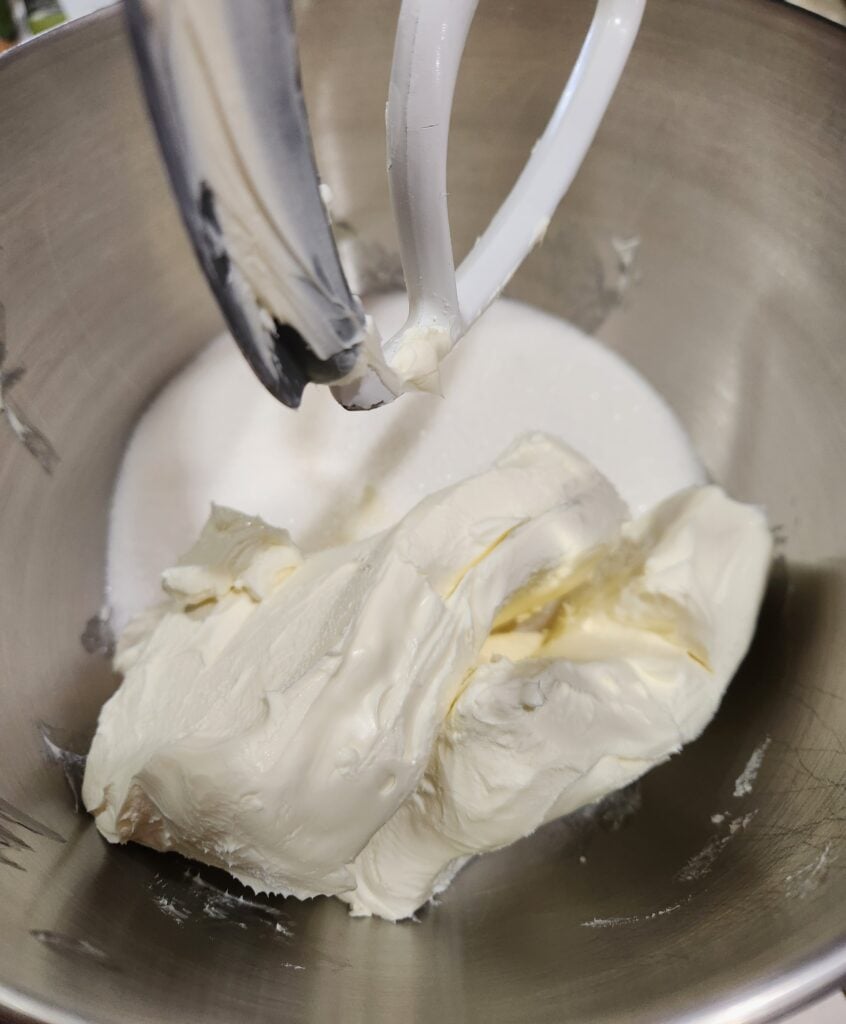 cream cheese and sugar in a mixing bowl.