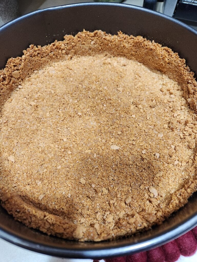 Graham cracker crust in a springform pan.