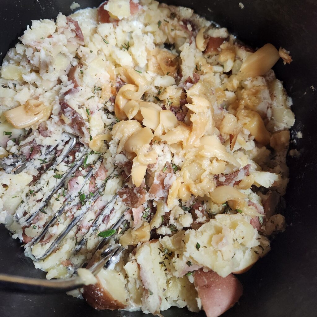 Adding the garlic to the potatoes.