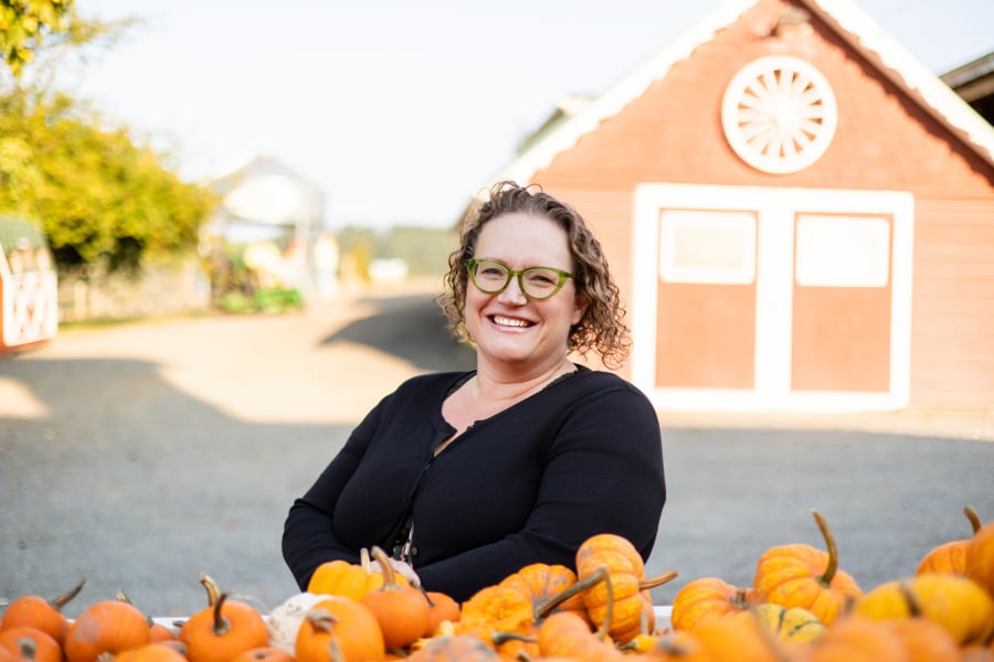 Amy, author at The Copper Table in a black sweater next to pumpkins.