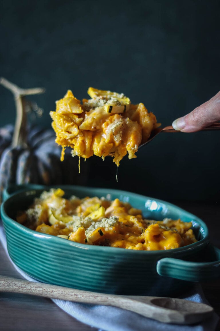 Mac and cheese with winter squash in a green casserole dish.