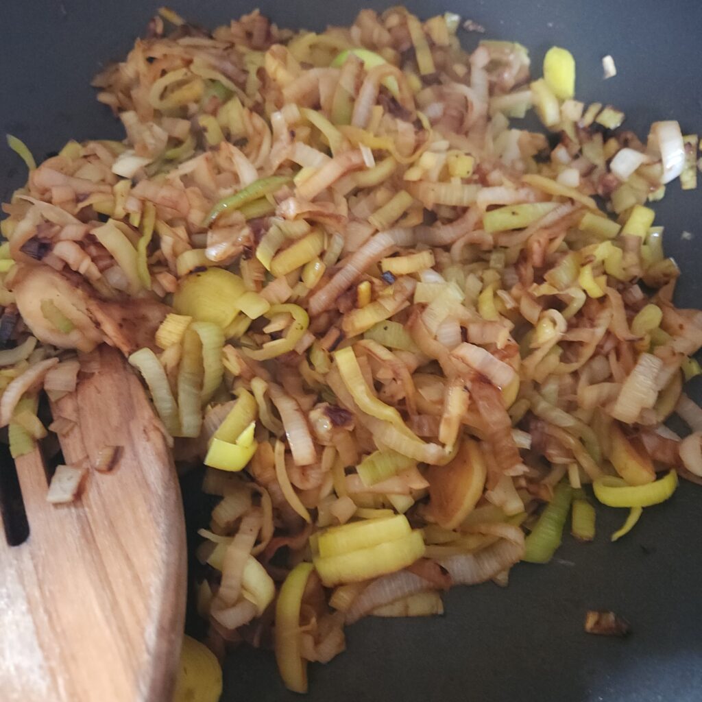 Sliced leeks cooking in a pan.