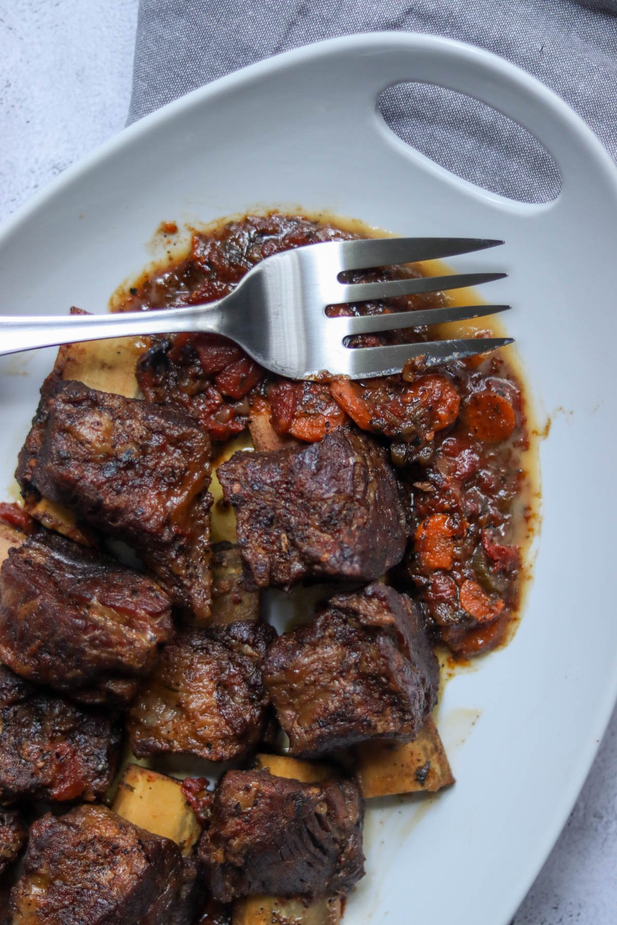 Braised short ribs on a white plate.