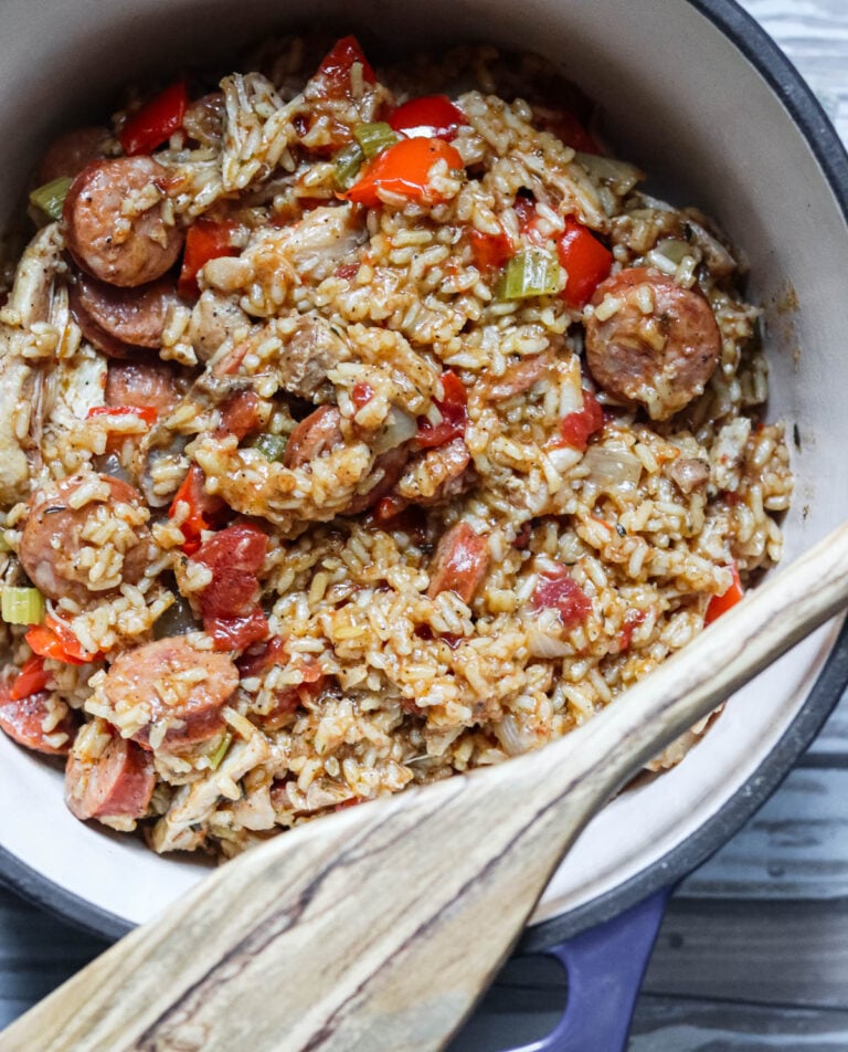 Pot of Jambalaya with a bamboo spatula.