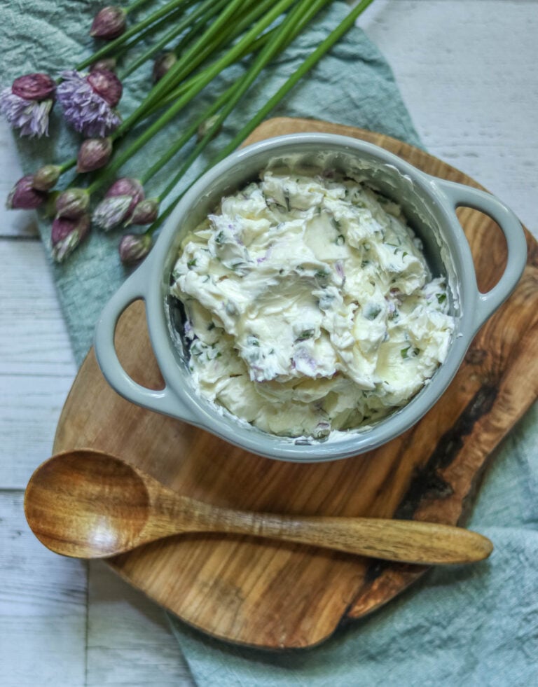Compound butter made with chives in a ceramic dish.