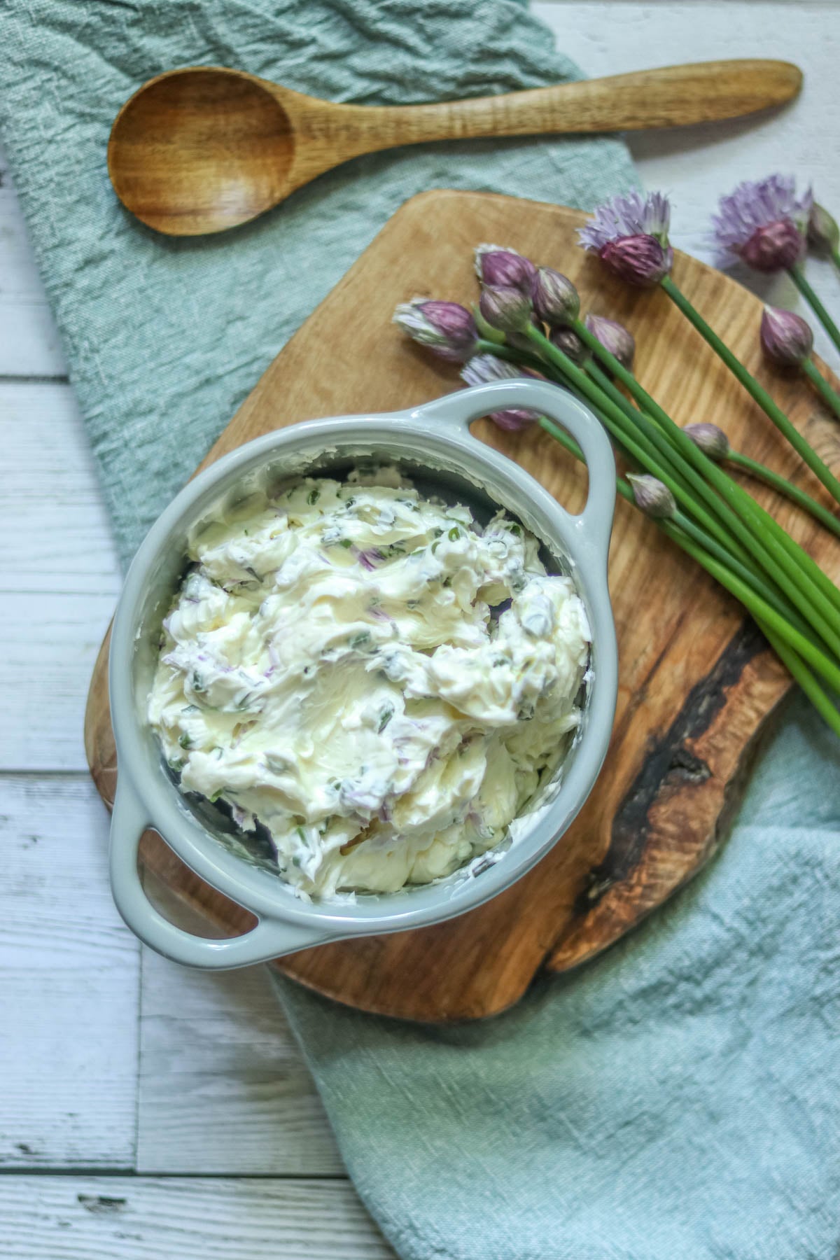 Chive compound butter on a white wood background.