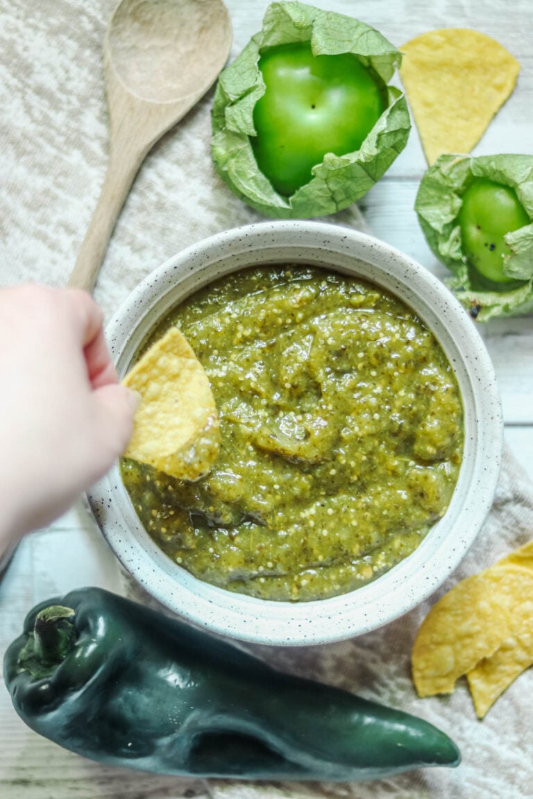 Bowl of green chile salsa with fresh tomatillos and poblano.