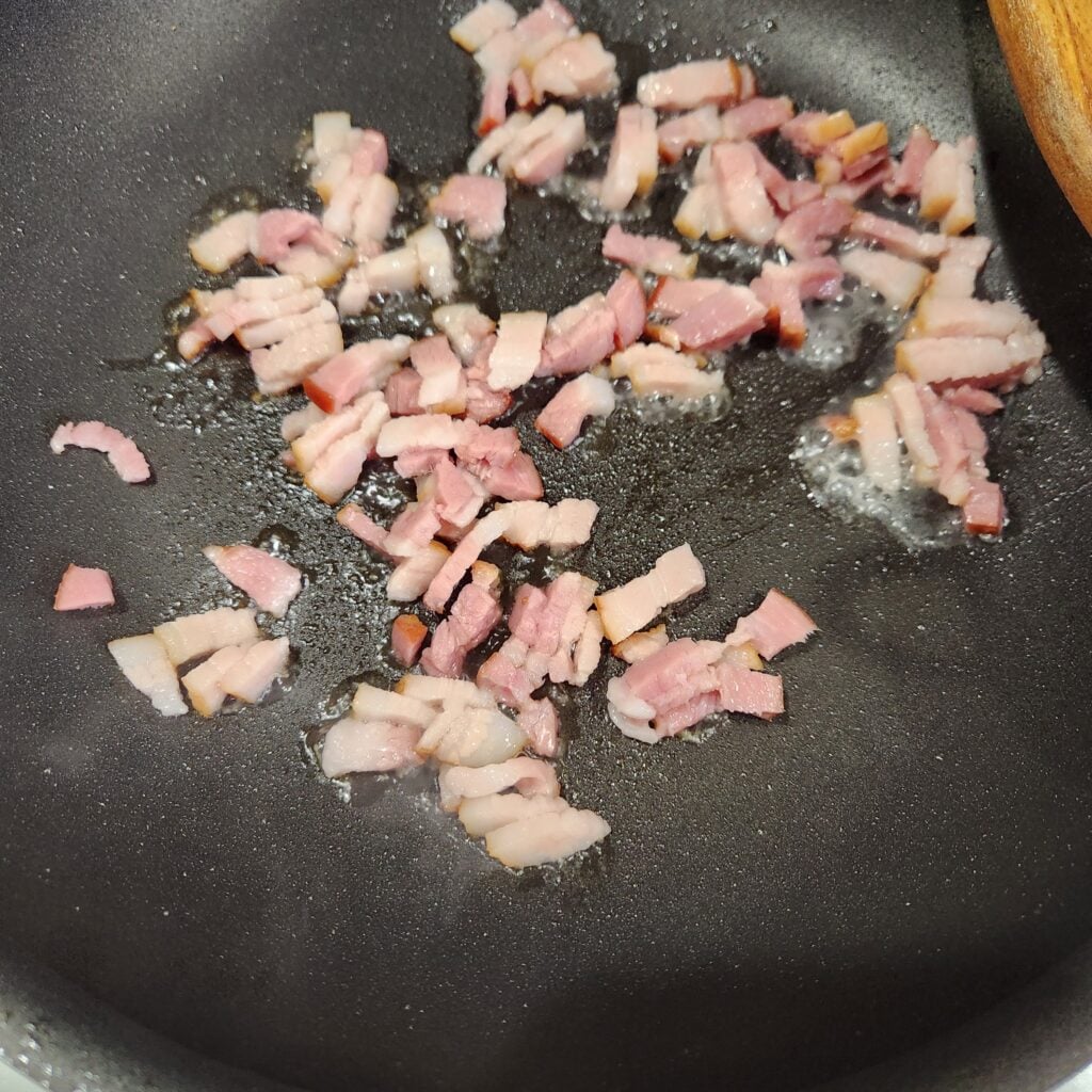 Browning bacon in a skillet.